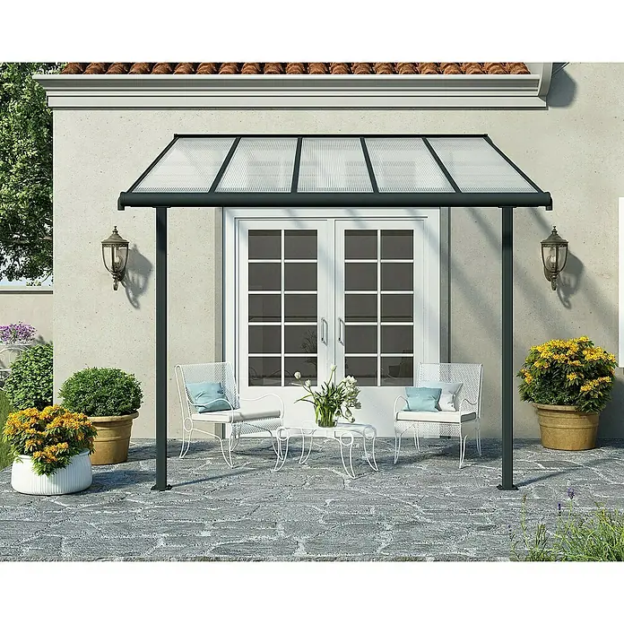 Palram – Canopia Terrassenüberdachung Sierra - B x T: 314 x 299 cm, Anthrazitgrau, Polycarbonat, Klar - Diese Aufnahme zeigt eine Terrassenüberdachung mit zwei Stühlen und einem Tisch. Die Überdachung bietet Schutz vor Wettereinflüssen und spendet Schatten.