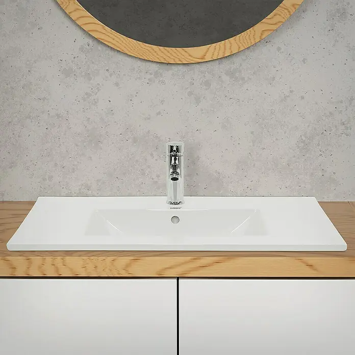 LuxeBath Einbauwaschbecken Aufsatzwaschtisch Weiß inkl. Ablaufgarnitur mit Überlauf Waschschale - Mit Überlauf, Weiß - Bild eines Waschbeckens mit Armatur. Das Becken ist weiß und rechteckig, eingebaut in eine Holzplatte, darüber hängt ein Spiegel.