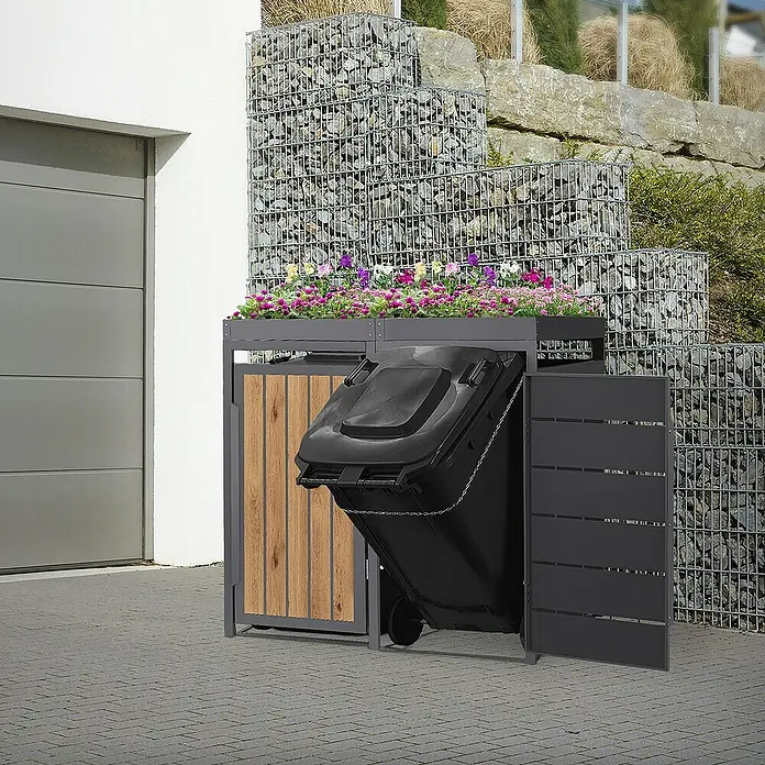 ML-Design Mülltonnenbox Mülltonnencontainer mit Pflanzdach für 2 Tonnen 120 oder 240 Liter - Stahl, Eiche hell, Geeignet für Anzahl Mülltonnen: 2 Stk. - Ein Mülltonnenbox mit Pflanzkasten und offenstehender Tür, die eine schwarze Mülltonne teilweise verdeckt.
