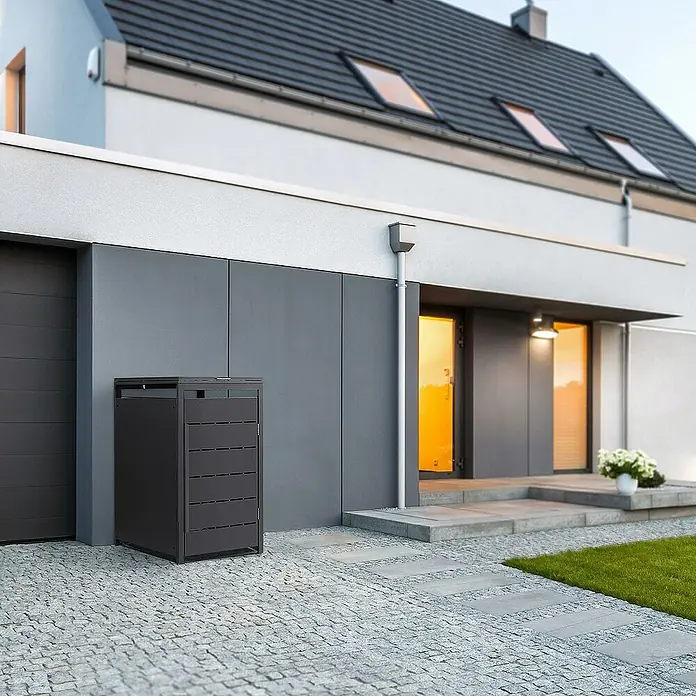 ML-Design Mülltonnenbox Mülltonnencontainer mit Klappdeckel/Tür für 1 Tonne 120 oder 240 Liter - Stahl, Anthrazit, Geeignet für Anzahl Mülltonnen: 1 Stk. - Eine moderne, anthrazitfarbene Mülltonnenbox steht vor einem stilvollen Haus und bietet eine elegante Lösung zur Mülltonnenaufbewahrung.