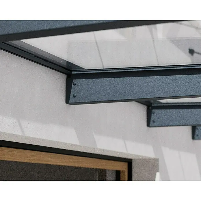 Palram – Canopia Pultvordach Sophia XL - 472 x 140 x 17 cm, Anthrazitgrau, Farbe Dach: Klar - Nahaufnahme einer modernen Glasüberdachung mit dunklen Metallrahmen, die an einer weißen Wand befestigt ist.
