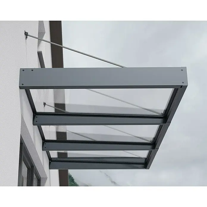Palram – Canopia Pultvordach Sophia XL - 286 x 140 x 17 cm, Anthrazitgrau, Farbe Dach: Klar - Nahaufnahme einer modernen Vordachkonstruktion aus Glas und grauem Metall, die an einer weißen Fassade befestigt ist.