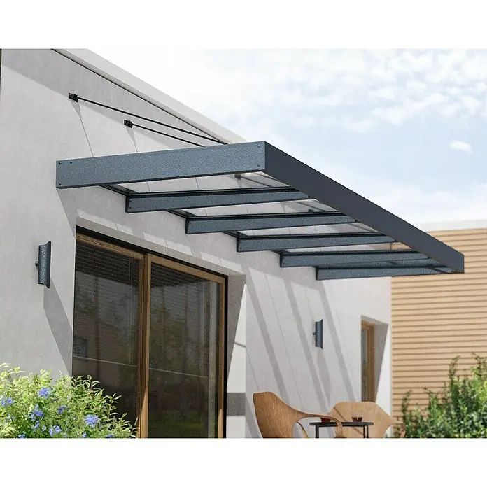 Palram – Canopia Pultvordach Sophia XL - 472 x 140 x 17 cm, Anthrazitgrau, Farbe Dach: Klar - Bild eines modernen Vordachs aus Metall und Glas, das über einer Terrassentür angebracht ist. Das Vordach bietet Schutz und ein stilvolles Design.