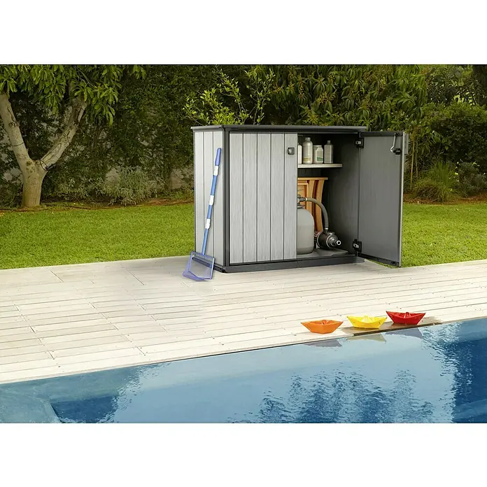 Keter Truhe Patio Store - L x B x H: 73,6 x 140 x 120 cm, Grau - Eine graue Gartentruhe aus Holz mit Poolzubehör und Spielzeugbooten am Poolrand.