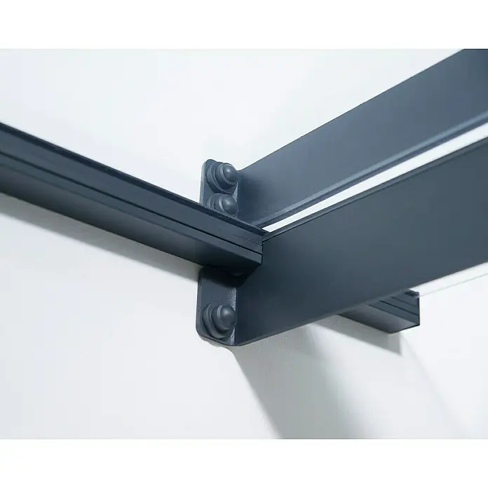 Palram – Canopia Pultvordach Nancy - 301 x 94 x 14 cm, Anthrazitgrau - Nahaufnahme einer dunkelgrauen Markise, die an einer weißen Wand befestigt ist und ein minimalistisches und modernes Design aufweist.