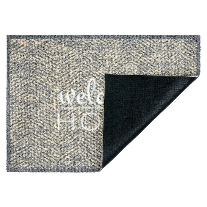 Schmutzfangmatte Miabella - Grau, 70 x 50 cm, 100 % Polyamid - Fußmatte mit Fischgrätenmuster und der Aufschrift "Welcome Home", teilweise umgeklappt, um die schwarze Rückseite zu zeigen.