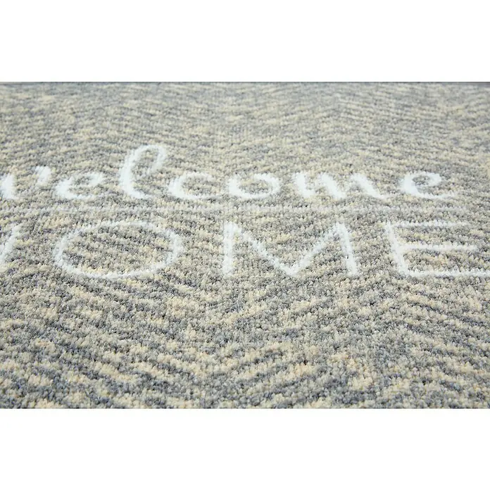 Schmutzfangmatte Miabella - Grau, 70 x 50 cm, 100 % Polyamid - Nahaufnahme einer Fußmatte mit der Aufschrift "Welcome Home" in Weiß. Die Matte hat ein Fischgrätenmuster in Grau- und Beigetönen.