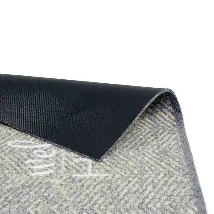 Schmutzfangmatte Miabella - Grau, 70 x 50 cm, 100 % Polyamid - Nahaufnahme einer grauen Fußmatte mit Fischgrätenmuster und dunkler Unterseite. Ideal für den Eingangsbereich, robust und stilvoll.