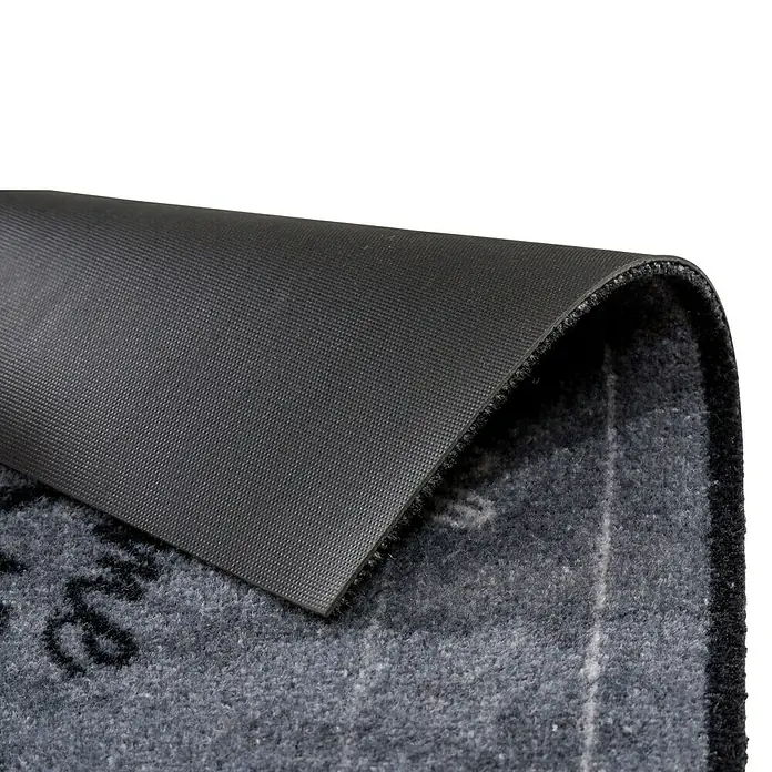 Fußmatte Deco Brush - Beton, 70 x 50 cm, 100 % Polyamid - Detailaufnahme einer grauen Fußmatte mit schwarzer Rückseite, die Stabilität und Rutschfestigkeit verspricht.