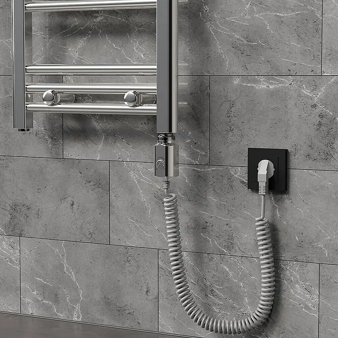 LuxeBath Austauschheizkörper - B x H: 4,5 x 4,5 cm - Bild eines beheizten Handtuchhalters mit einem spiralförmigen Kabel, das an eine Steckdose an einer gemusterten grauen Wand angeschlossen ist.