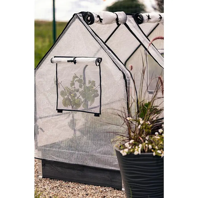 Upyard Hochbeet-Überdachung Gewächshaus - Passend für: Palettenrahmen-Hochbeete 120 × 80 cm - Nahaufnahme eines Gewächshauses mit Fenstern und einem Topf mit Pflanzen im Vordergrund.