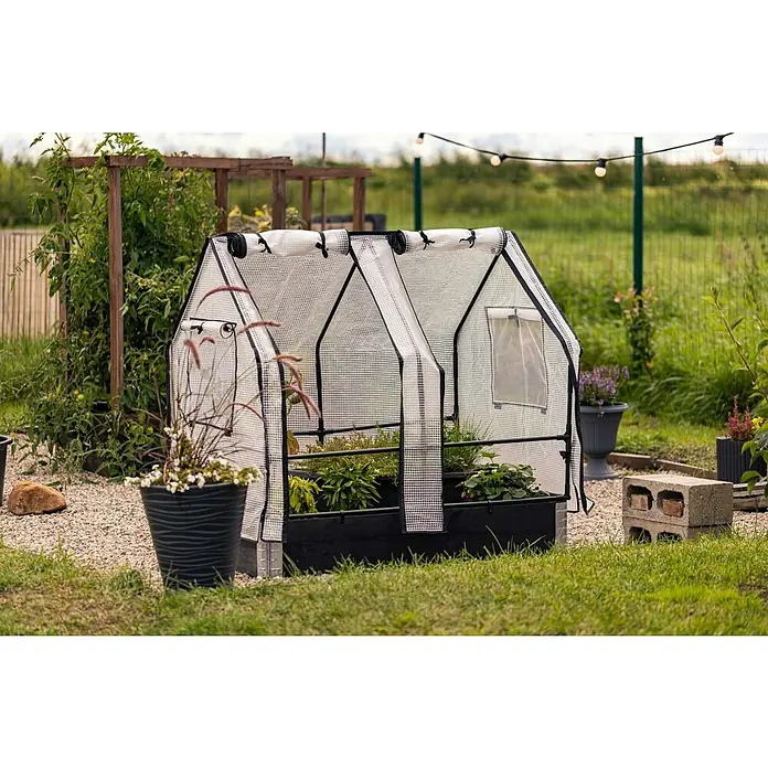 Upyard Hochbeet-Überdachung Gewächshaus - Passend für: Palettenrahmen-Hochbeete 120 × 80 cm - Nahaufnahme eines Gewächshauses im Garten mit Pflanzen im Inneren, umgeben von Grün und Gartenambiente.