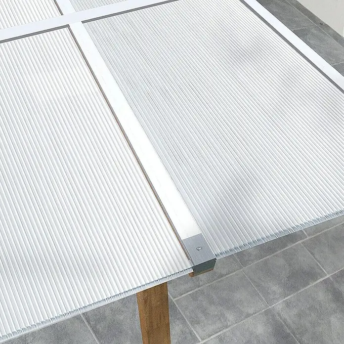 Floordirekt Hohlkammerplatte Doppelstegplatte Polycarbonat 6 mm - 60,5 x 121 cm Transparent -  - Nahaufnahme eines durchsichtigen Wellplatten-Dachs mit weißen Rahmen und einer Holzstütze. Das Dach ist auf grauen Fliesen montiert.