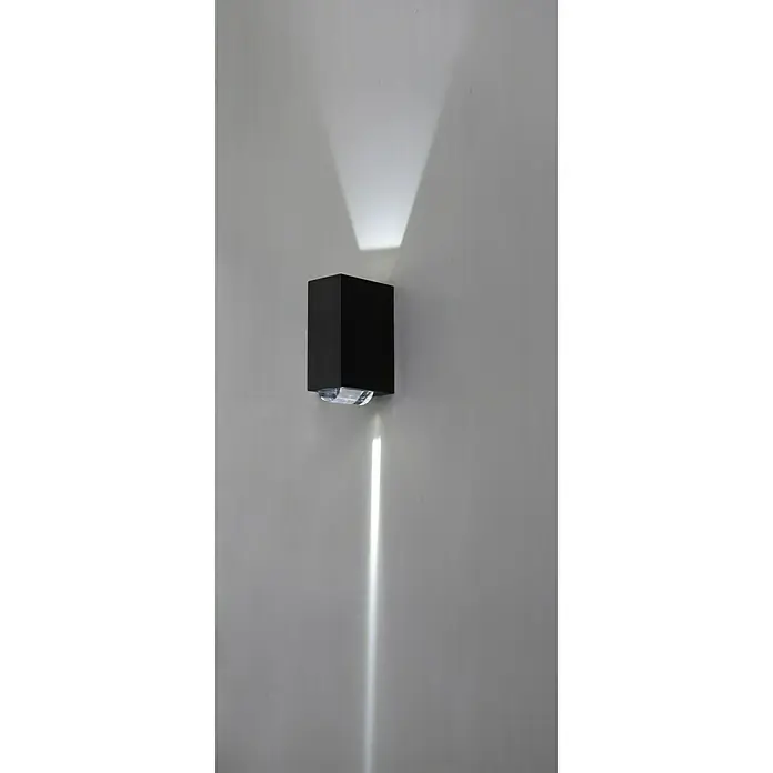Lutec Aplique exterior LED Evans - 12 W, 19,2 x 7 x 10,9 cm, Antracita, Claro, IP54 - Un aplique de pared negro moderno emite una luz brillante hacia arriba y hacia abajo, creando un efecto de iluminación atmosférico.