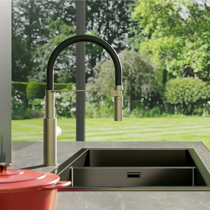 Lenz Spültischarmatur Nalu - Nickel/Schwarz, Matt - Elegante Küchenarmatur mit schwarzem Schwanenhals und Messing-Finish vor Fenster mit Gartenblick.