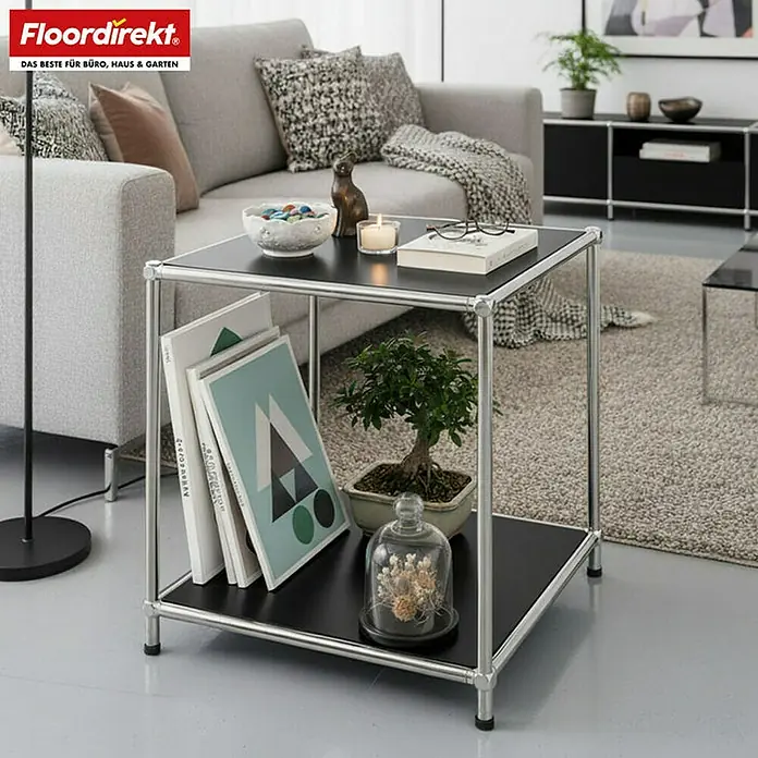 Floordirekt Metallregal Concept Epure MK-012 - 40 x 40 x 46 cm Schwarz - H x B x T: 46 x 40 x 40 cm, Anzahl Böden: 2 Stk., Schrauben, Schwarz - Nahaufnahme eines quadratischen Beistelltisches mit schwarzer Oberfläche und silbernem Gestell, dekoriert mit Büchern und einer Pflanze.