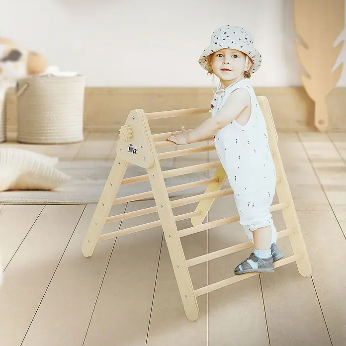ECD Germany Klettergerüst Kletterdreieck trainiert Gleichgewicht & Balance ab 2 Jahren - 73 x 72 x 70 cm, Holz, Braun - Ein kleines Kind klettert auf einem Holz-Kletterdreieck mit Sprossen. Das Dreieck steht in einem hellen Raum mit Holzboden.