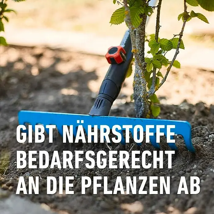 Compo Langzeitdünger Bäume, Hecken, Sträucher - 2 kg - Eine blaue Gartenrechen liegt auf der Erde und daneben steht ein junger Baum. Im Vordergrund steht der Text "Gibt Nährstoffe bedarfsgerecht an die Pflanzen ab".