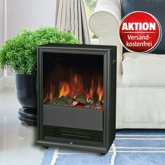 Voltomat HEATING Elektrischer Kamin - 2.000 W, Schwarz, 27,5 x 43 x 62,5 cm - Elektrischer Kamin mit simulierten Flammen. Der Kamin steht auf einem blauen Teppich neben einer Pflanze und einem Sofa. Versandkostenfrei-Aktion.