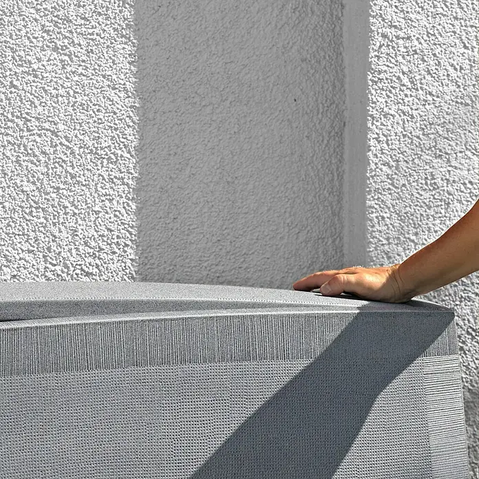 Arves Regenspeicher Noblesse - 275 l, Granitfarben, 1 Stk. - Nahaufnahme eines grauen Sofas mit einer Hand darauf, vor einer strukturierten Wand.
