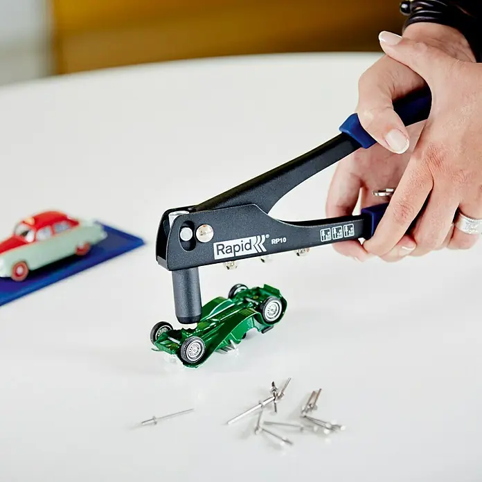 Rapid Blindnietzangen-Set RP10 - Geeignet für: Aluminiumnieten (Ø 3,2 mm, Ø 4 mm, Ø 4,8 mm) - Eine Rapid RP10 Nietzange wird benutzt, um ein Spielzeugauto zu reparieren. Dieses Werkzeug ist ideal für Heimwerkerprojekte.