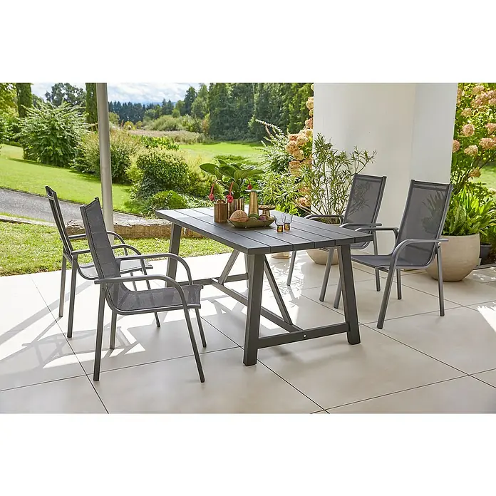 Sunfun Gartenmöbel-Set Melina/Maja - 5 -tlg., Akazie, Aluminium, Textilen, Schwarz/Anthrazit - Grauer Gartentisch mit vier Stühlen auf einer Terrasse mit Pflanzen und Garten im Hintergrund.