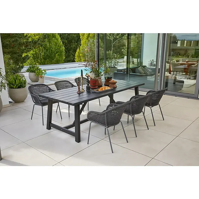Sunfun Gartenmöbel-Set Melina/Sarah Rope - 7 -tlg., Akazie, Stahl, Olefin, Schwarz/Night-Grey - Ein grauer Esstisch mit sechs Stühlen steht auf einer Terrasse neben einem Pool. Der Tisch ist mit Dekorationsgegenständen versehen.