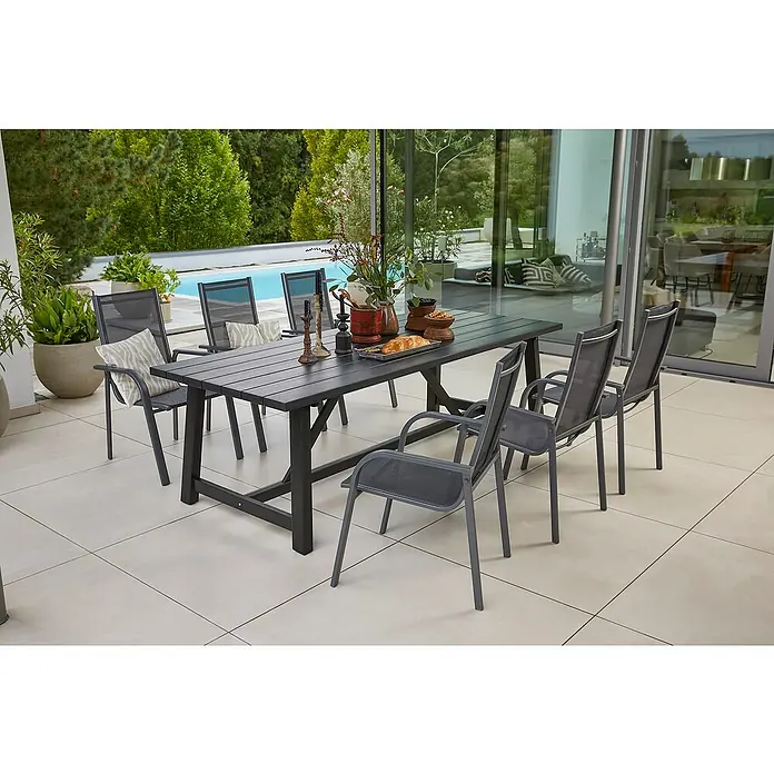 Sunfun Gartenmöbel-Set Melina/Maja - 7 -tlg., Akazie, Aluminium, Textilen, Schwarz/Anthrazit, Gartenstuhl stapelbar - Ein Gartentisch mit sechs Stühlen auf einer Terrasse, dekoriert mit Blumen und Speisen, ideal für Mahlzeiten im Freien.