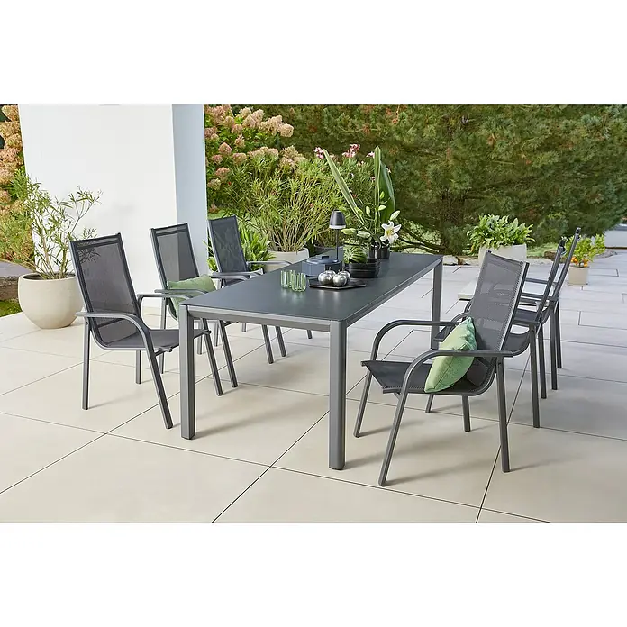 Sunfun Gartenmöbel-Set Maja - 7 -tlg., Aluminium, Textilen, Anthrazit, Night-Grey, Gartenstuhl stapelbar - Bild eines modernen Gartentisches mit Stühlen auf einer Terrasse, umgeben von üppigem Grün. Perfekt für Mahlzeiten im Freien.
