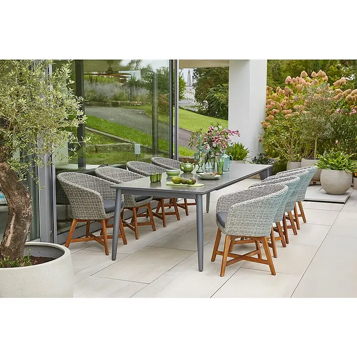 Sunfun Gartenmöbel-Set Solo/Pauline I - 9 -tlg., Aluminium, Sintered Stone, Polyrattan, Akazie, Grau/Naturbraun/Night-Grey, Tischplatte ausziehbar - Essgruppe im Freien mit einem langen Tisch und acht Korbstühlen mit grauen Kissen. Die graue Tischplatte passt gut zu den Stuhlgestellen.