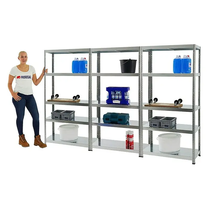 Proregal Metallregal Mega Deal Steel Eagle - Traglast pro Boden: 130 kg, Anzahl Böden: 5 Stk., Stecken, Verzinkt - Das Bild zeigt ein stabiles, verzinktes Metallregal mit mehreren Regalböden, beladen mit verschiedenen Gegenständen und einer Frau daneben.