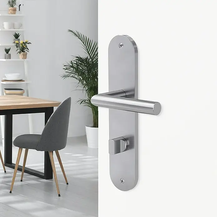 Diamond Doors Modern Zimmertürgarnitur WC Alaska - Edelstahl, Stärke Tür: 38 mm - 45 mm, Schlitzkopf/Olive - Nahaufnahme einer modernen, satinierten Edelstahl-Türgarnitur, die an einer weißen Tür befestigt ist und durch ihr schlichtes Design besticht.