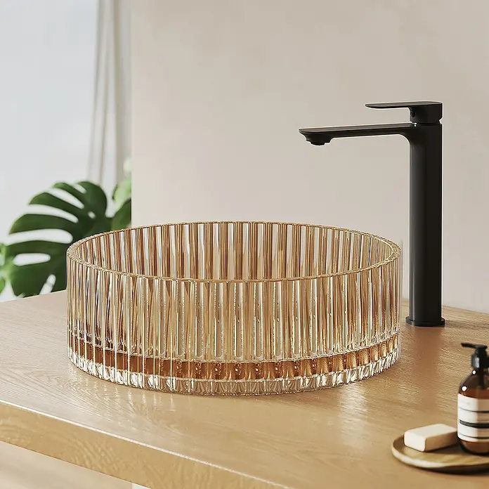 Emke Aufsatzwaschbecken CB32 - 40 x 40 cm, Hahnloch: Ohne, Ohne Überlauf, Roségold - Elegantes Waschbecken aus geriffeltem Glas in Bernsteinoptik mit einer stilvollen, schwarzen Armatur auf einem hellen Holzunterschrank.