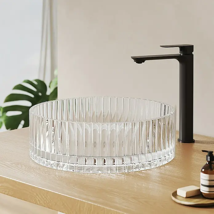 Emke Aufsatzwaschbecken CB32 - 40 x 40 cm, Hahnloch: Ohne, Ohne Überlauf, Klar - Elegantes Waschbecken aus klarem Glas mit geripptem Design und einem modernen, schwarzen Wasserhahn auf einer hellen Holzoberfläche.