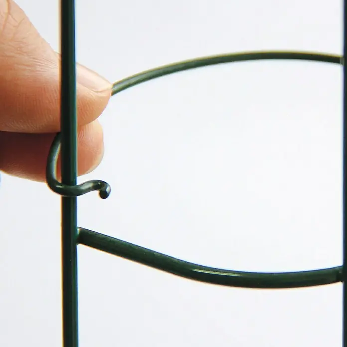 Bellissa Tomatensäule - 120 cm - Detailaufnahme eines grünen Metall-Pflanzenturm-Verbindungsstücks mit einem Finger, der das Hakenelement hält, ideal für Gartenliebhaber.