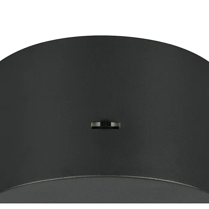 Trio Leuchten Laguna LED-Pendelleuchte - 5 W, B x H: 18 x 200 cm, Schwarz matt, Warmweiß, Anzahl Leuchtmittel: 1 Stk. - Nahaufnahme eines schwarzen runden Geräts mit kleinem Schalter in der Mitte, Fokus auf Design und Funktionalität.