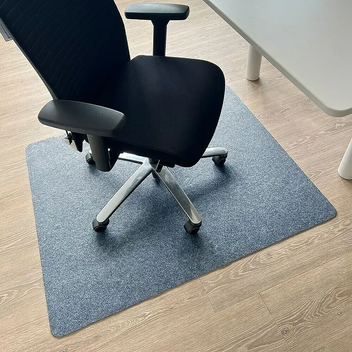 Fußbodenschutzmatte Viking - 120 x 100 cm, Grau, Polyester - Eine Bürostuhlmatte in Grau liegt unter einem Bürostuhl mit silbernem Gestell auf einem Holzboden, um diesen vor Beschädigungen zu schützen.