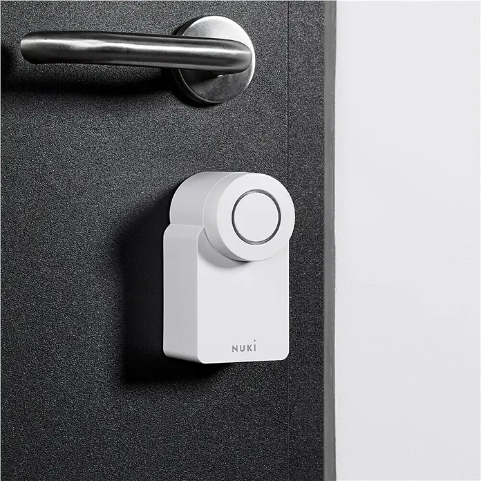 Nuki Elektronisches Türschloss Smart Lock Go - Über App, Geeignet für: Türen - Nahaufnahme eines Nuki Smart Lock an einer Tür mit Türgriff, das moderne Sicherheit und Komfort für Ihr Zuhause bietet.