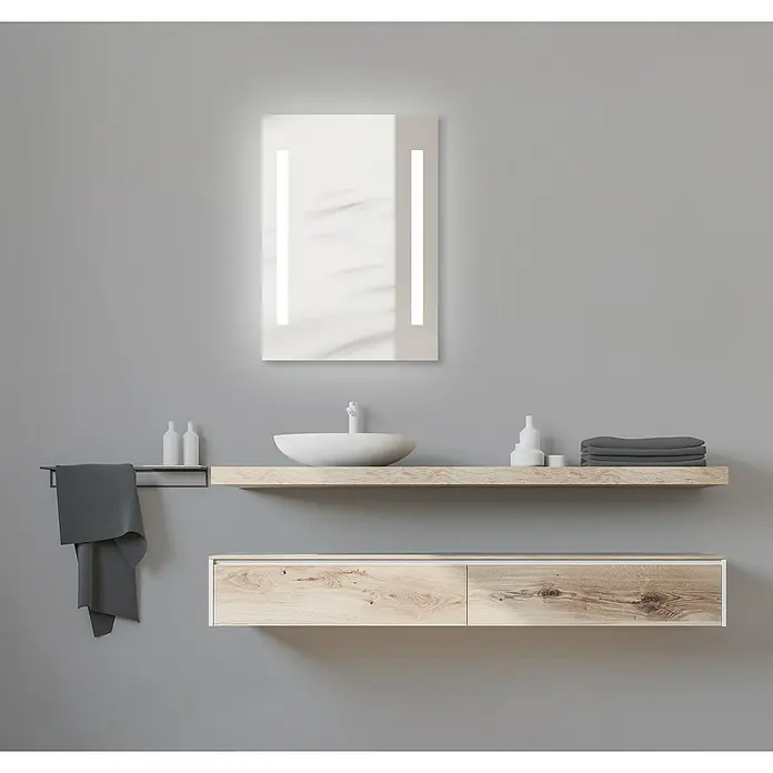 DSK LED-Lichtspiegel Chrystal Creek - 50 x 70 cm, Ohne eingebaute Digitaluhr - Badezimmer mit einem beleuchteten Spiegel über einem Waschbecken mit Holzablage und grauem Handtuch für ein modernes Design.