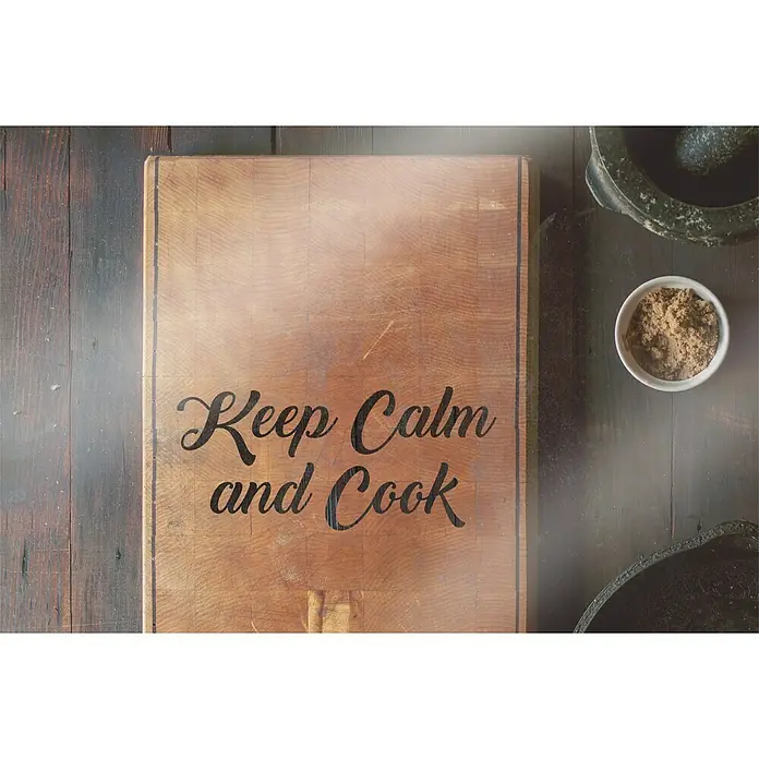 CUCINE Küchenrückwand - Keep Calm and Cook, 60 x 40 cm, Stärke: 6 mm, Einscheibensicherheitsglas (ESG) - Küchentisch mit Schneidebrett mit der Aufschrift "Keep Calm and Cook", einer Schale mit Gewürzen und einem Mörser.