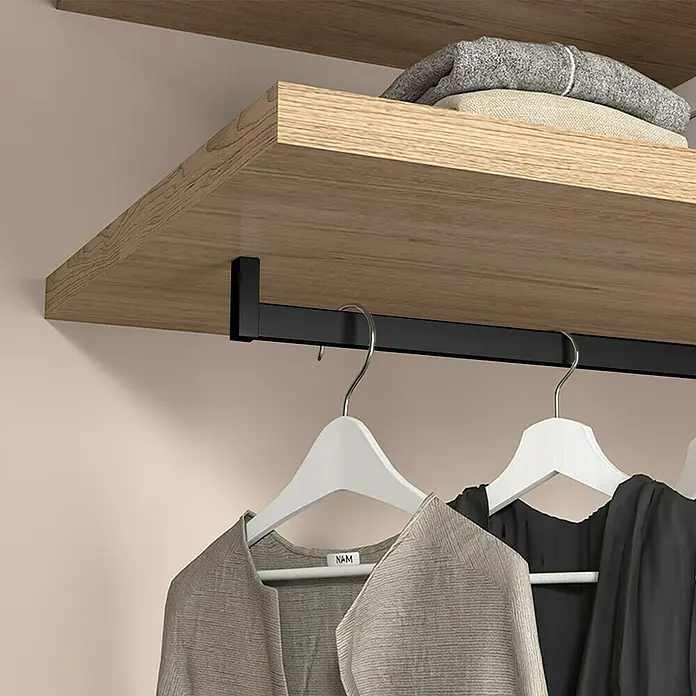 Emuca Kleiderstangen-Set Luxe - Länge: 75 cm, Tiefschwarz - Nahaufnahme eines Kleiderschranks mit Holzböden, einer schwarzen Kleiderstange und Kleidung an weißen Kleiderbügeln.