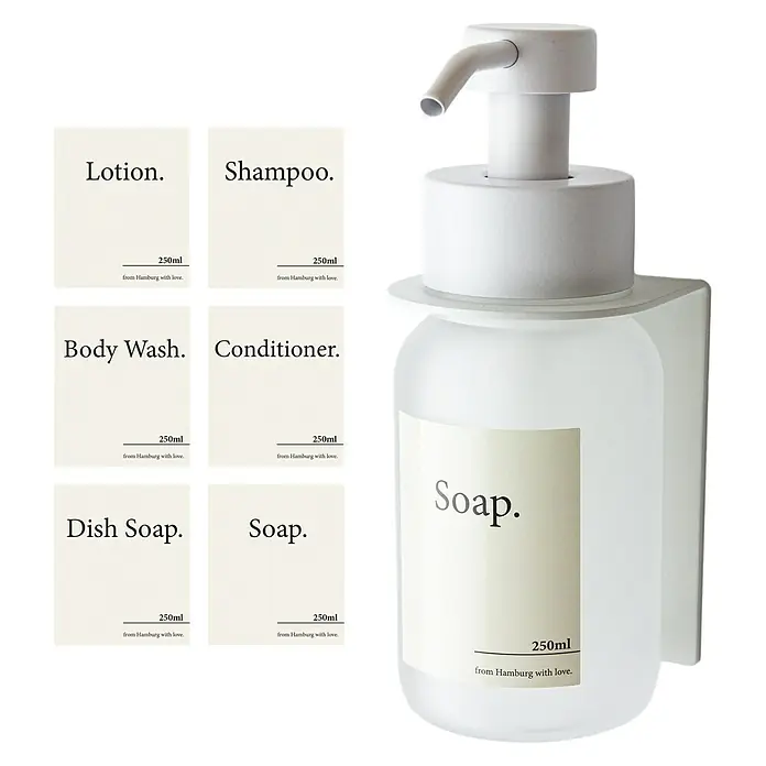 Designfabrik Hamburg Seifenspender - Edelstahl, Weiß/Satiniertes Glas, Wandmontage - Weißer Seifenspender mit verschiedenen Etiketten, wie Lotion, Shampoo, Duschgel, Spülmittel und Seife, alle mit minimalistischem Design.