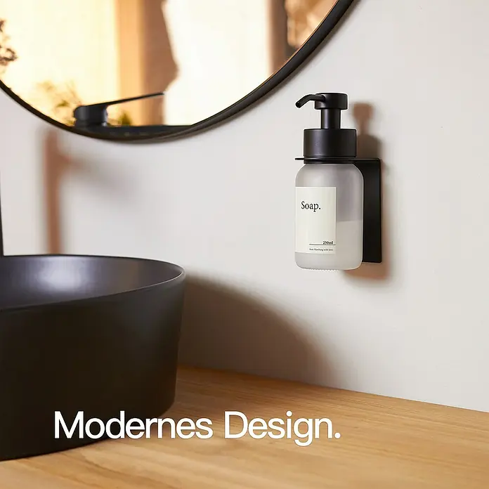 Designfabrik Hamburg Seifenspender - Edelstahl, Schwarz/Satiniertes Glas, Wandmontage - Ein modernes Badezimmerdesign mit einem eleganten, schwarzen Waschbecken und einem Wandseifenspender mit schlichtem Etikett.