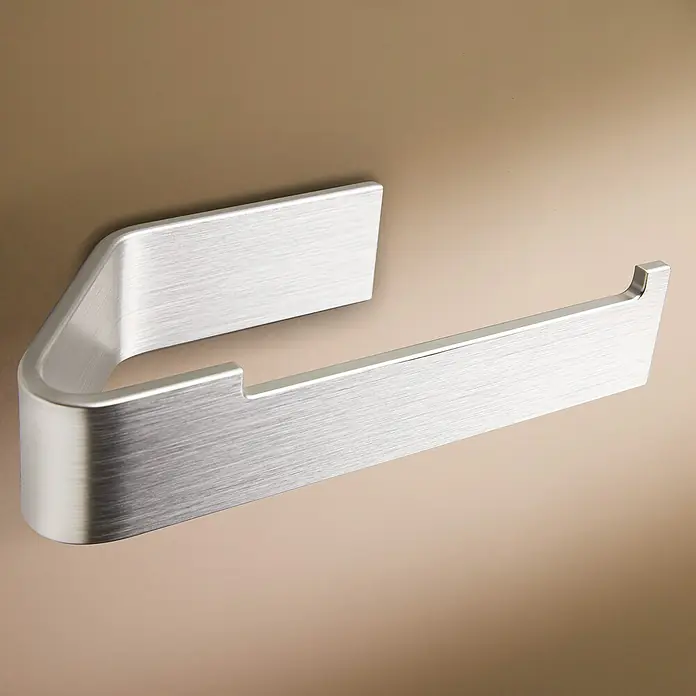 Designfabrik Hamburg Toilettenpapierhalter - Silber gebürstet, Matt - Nahaufnahme eines modernen, gebürsteten Edelstahl-Toilettenpapierhalters an einer beigen Wand.