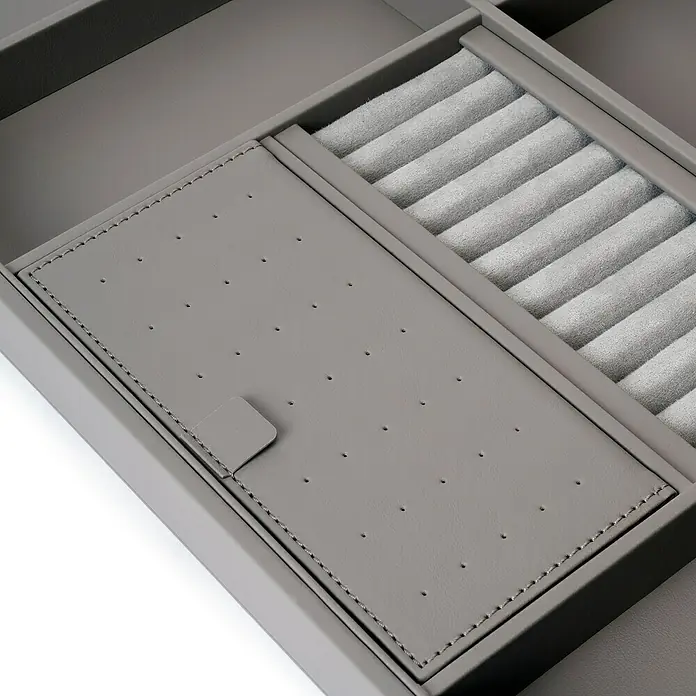 Emuca Schrank-Organisator Quartz - Breitenverstellung: 562 mm - 688 mm, Höhe: 66 mm, Traglast: 30 kg - Nahaufnahme einer grauen Schmuckschatulle mit Ohrringhalter und Ringfächern. Elegante und praktische Aufbewahrung für Schmuckstücke.