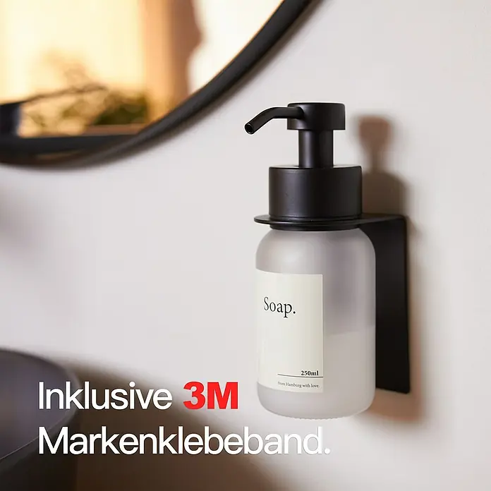 Designfabrik Hamburg Seifenspender - Edelstahl, Schwarz/Satiniertes Glas, Wandmontage - Nahaufnahme eines matten Glasseifenspenders mit schwarzem Spenderkopf und Wandhalterung. Inklusive 3M-Markenklebeband für einfache Montage.