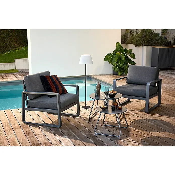 Sunfun Maja Loungesessel - B x T x H: 76 x 76 x 74,5 cm, Aluminium, Olefin, Night-Grey - Gartenmöbel-Set mit zwei grauen Sesseln und zwei runden Beistelltischen aus Metall mit Dekorationen auf einer Holzterrasse.
