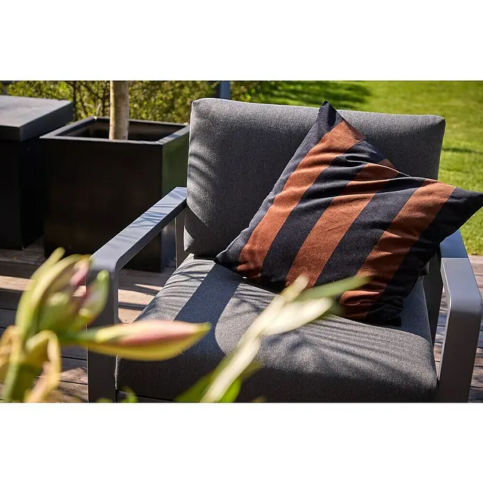 Sunfun Maja Loungesessel - B x T x H: 76 x 76 x 74,5 cm, Aluminium, Olefin, Night-Grey - Nahaufnahme eines grauen Sessels mit einem gestreiften Kissen im Freien, der zum Entspannen einlädt. Die schlichte Eleganz passt perfekt in jeden Garten.