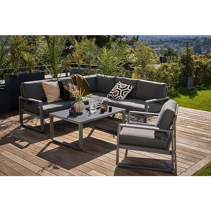 Sunfun Maja Loungemöbel-Set - 3 -tlg., Aluminium, Sicherheitsglas, Olefin, Night-Grey - Elegantes graues Loungeset auf einer Holzterrasse. Das Set besteht aus Sofa, Sessel und Tisch und ist mit Kissen und Dekorationen versehen.