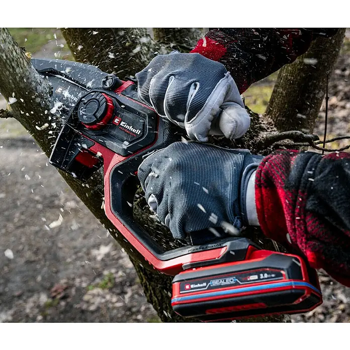 Einhell Professional Akku-Kettensäge GP-PS 18/20 LI - 18 V, Li-Ionen, Ohne Akku, Schwertlänge: 19,2 cm - Nahaufnahme der Einhell Akku-Astsäge beim Sägen eines Astes, mit Handschuhen für sicheres Arbeiten, ideal für Gartenarbeiten.